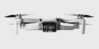 DJI Mini 4K Fly More Combo med drone, fjernbetjening og ekstra batterier vist på hvid baggrund.
