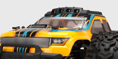 Grøn og sort HBX Tornado Brushless fjernstyret bil i fuld fart på en grusvej med støvskyer.