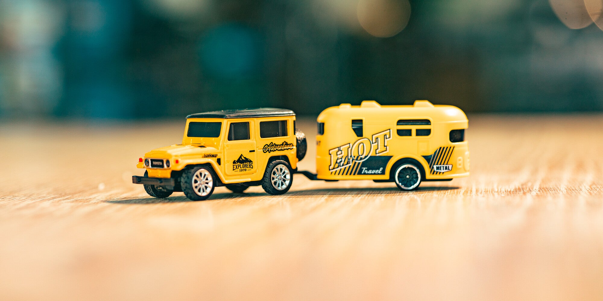Mini Land Cruiser i gul med trailer som står på et bord