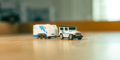 Mini Land cruiser i hvid som står på et bord med sløret baggrund 
