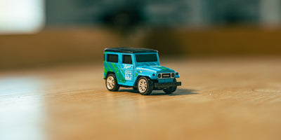 Mini Land Cruiser i blå på bord set skråt forfra på et bord med sløret baggrund