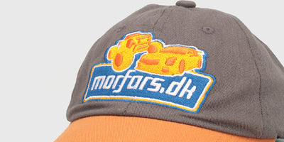 Sort Morfars.dk kasket med broderet logo i hvid og rød set skråt forfra på en hvid baggrund.