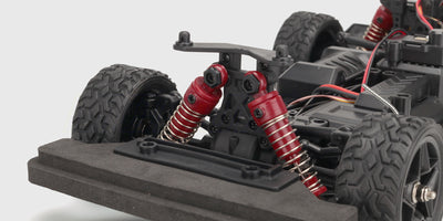 Nærbillede af de justerbare støddæmpere på en Hurricane Drift fjernstyret bil.