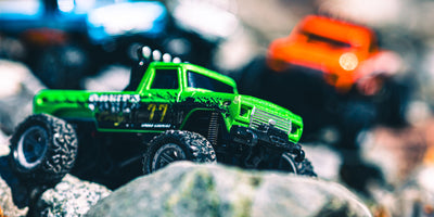 Mini RC Car pick-up i grøn på sten med orange og blå sløret i baggrunden