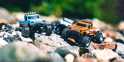 Mini RC Car Pick up i blå og orange på sten med sløret baggrund