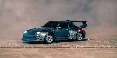 Den grå Mini BTD drifter med hjulspin og forlygterne tændt 