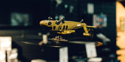 Sort og rød Top Hunter fjernstyret helikopter med dobbelt rotor og landingsstel på en hvid baggrund.