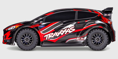 Blå Traxxas Ford Fiesta ST Rally Brushless fjernstyret bil set skråt forfra på hvid baggrund.