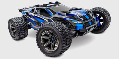 Blå Traxxas Rustler 4x4 Ultimate fjernstyret bil med store offroad dæk set skråt forfra på hvid baggrund.
