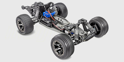 Blå Traxxas Rustler Brushless fjernstyret stadium truck med offroad-dæk set fra siden på hvid baggrund.