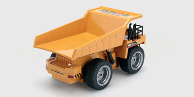 Gul fjernstyret dumper med bevægeligt lad og grove dæk til leg i terræn.