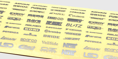 Ark med små sølvfarvede Smallz-klistermærker med forskellige logoer til dekoration af fjernstyrede biler.