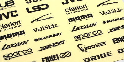 Klistermærker Stylez med sorte logoer som DUB og JBL på et gennemsigtigt ark til fjernstyrede biler.